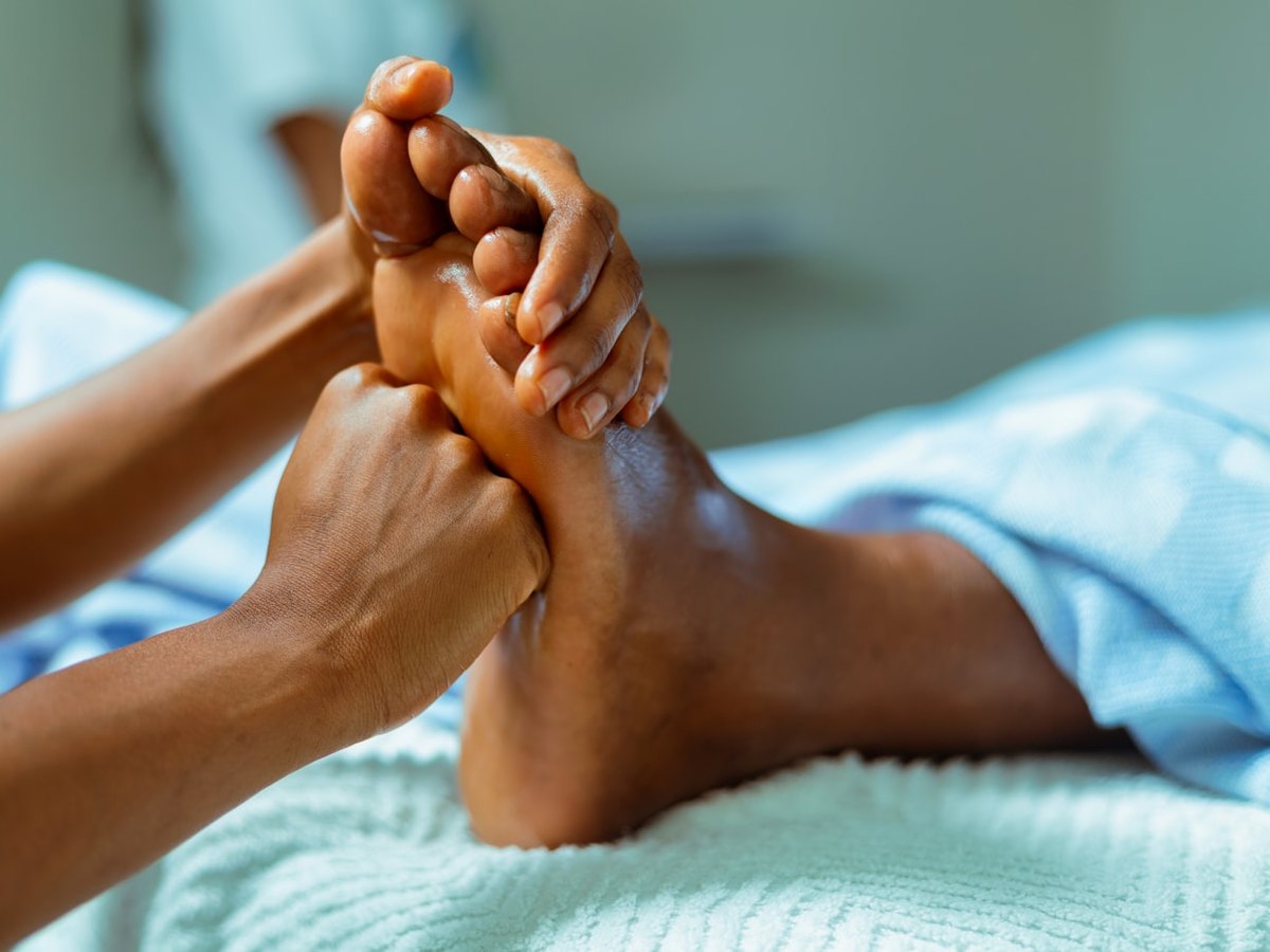 Reflexologia podal sendo aplicada nos pés